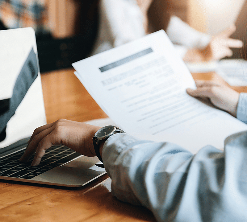 Person working on laptop with documents