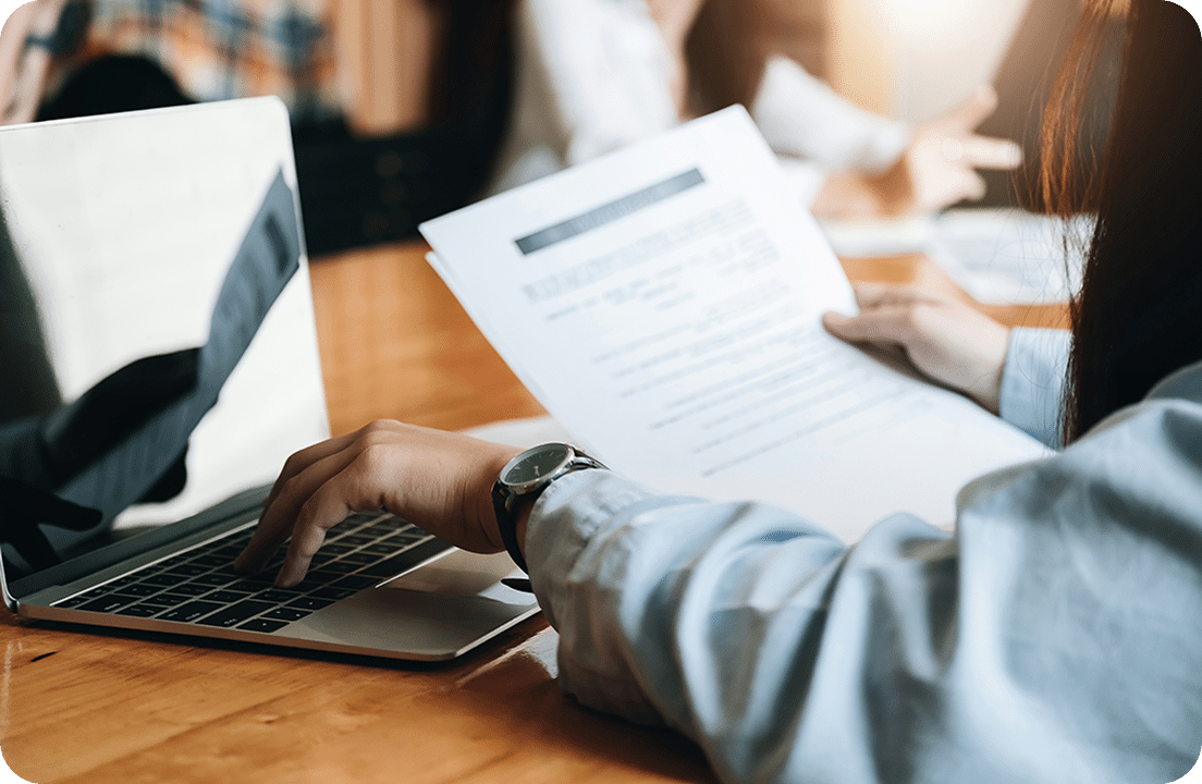 Person working on laptop with documents